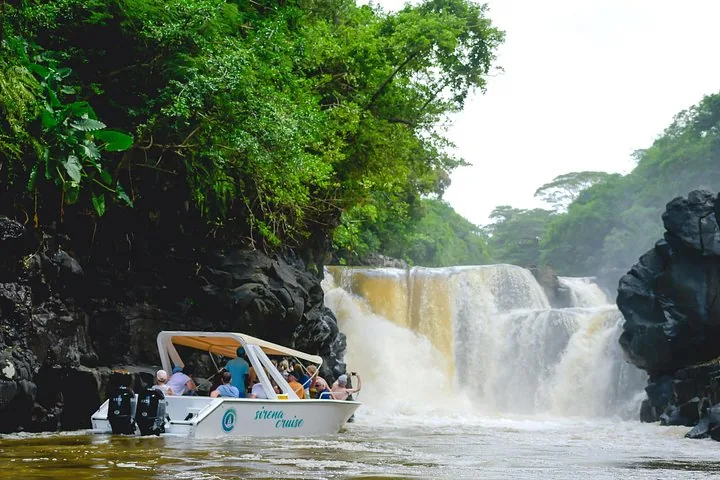 Vedette rapide avec des passagers près d'une grande cascade pittoresque se jetant dans une rivière.